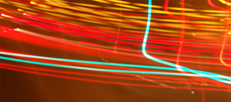 Long-exposure photograph of streaking coloured lights